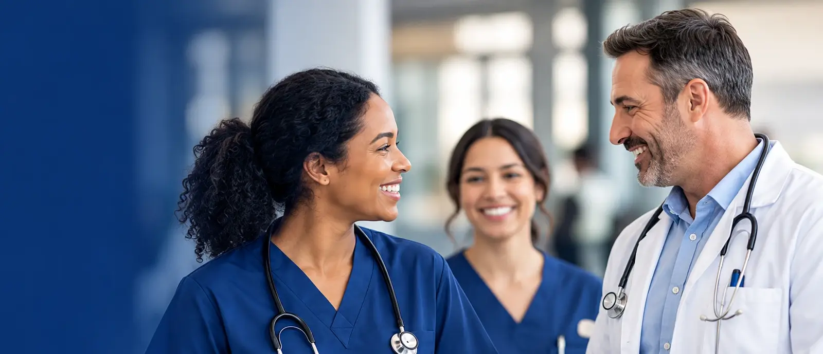 Nurses and a physician talking in a hospital corridor